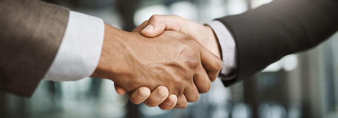 Two men in suits shaking hands